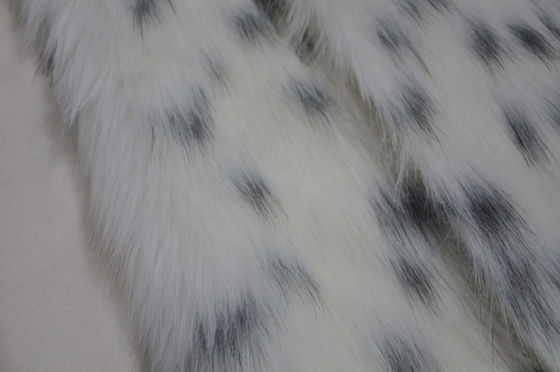 zwarte vlek op een witte Stof van het achtergrond Lange Haarbont, Lange pluchestof: Het perfecte mengsel van comfort en manier