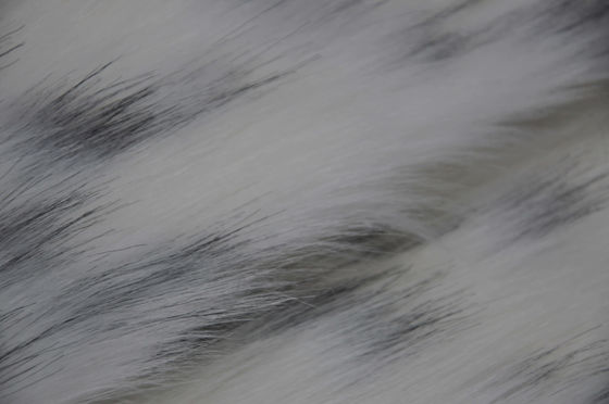zwarte vlek op een witte Stof van het achtergrond Lange Haarbont, Lange pluchestof: Het perfecte mengsel van comfort en manier